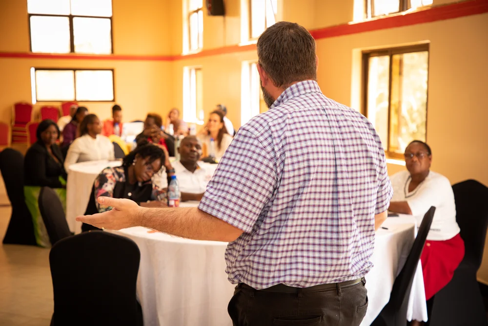 A facilitator leading a discussion with participants at a WezaCare workshop